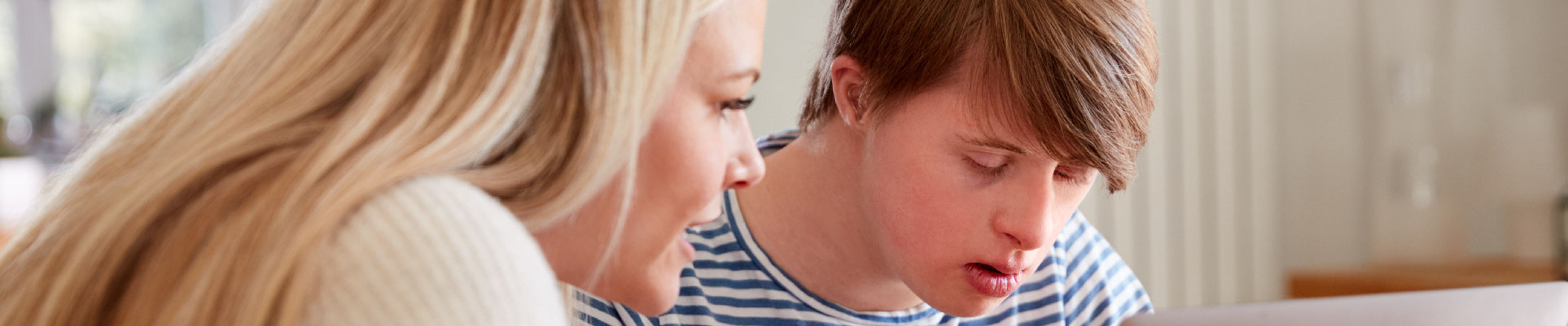 A woman tutoring a participant with down syndrome