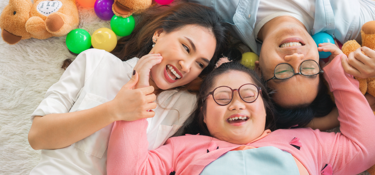 Happy Asian family laying on carpet in living room and smile with their daughter down syndrome child-04