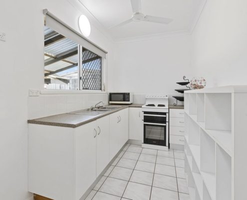 Kitchen all in white showing an array of cupboards and appliances